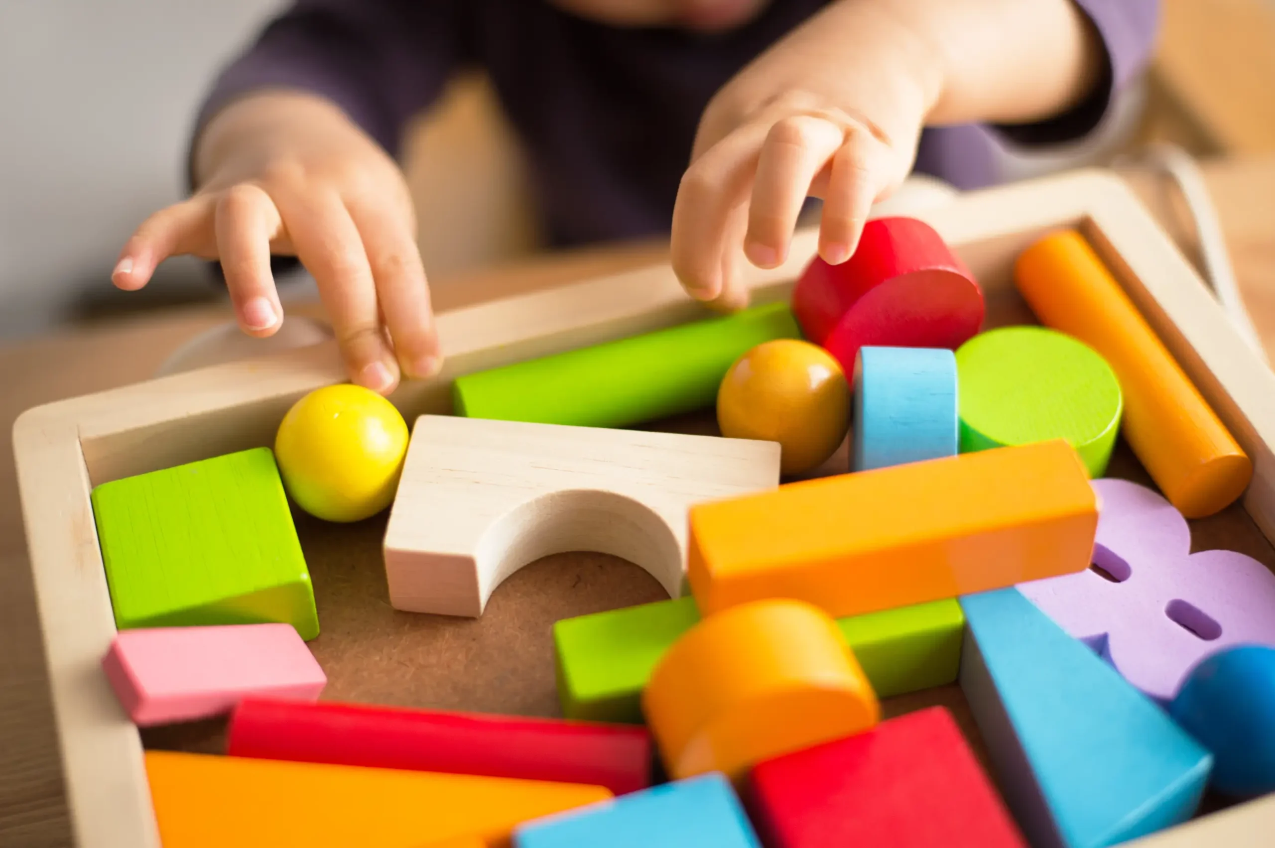 A child hands holding wooden toys